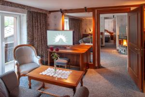 采爾馬特的住宿－桑尼酒店，客厅配有书桌和电视。