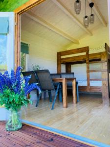 a vase of flowers on a porch with a table and chairs at Orupõhja kämpingud ja telkimisala in Põlva