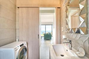 Un baño con lavadora y lavabo. en Blue Green Villa Kalyves eco pool premium quality, en Kalyves