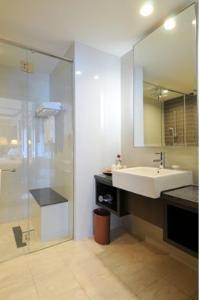 uma casa de banho com um lavatório e uma cabina de duche em vidro. em Micasa All Suites Hotel em Kuala Lumpur