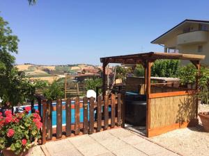 uma cerca de madeira com um gazebo e uma piscina em Ca'Silvia em San Savino