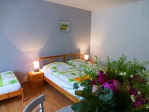 ein Schlafzimmer mit einem Bett und einem Tisch mit Blumen in der Unterkunft Ubytovanie na Frantšachte in Banská Štiavnica