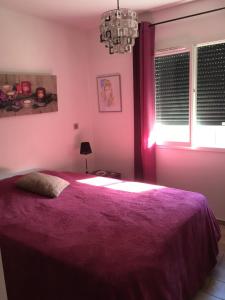 1 dormitorio con cama morada y ventana en VILLA 800 MÈTRES DE LA PLAGE, en Andernos-les-Bains