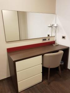 a desk with a mirror and a chair in a room at Swiss-Belboutique Bneid Al Gar Kuwait in Kuwait