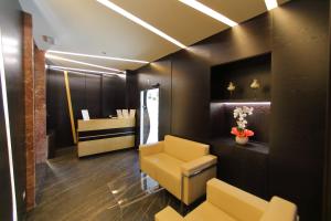 a waiting room with a yellow chair and a desk at Hotel Bell'arrivo by Dori in Peschiera del Garda