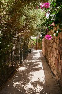einen Gehweg mit einer Bank und Blumen an der Wand in der Unterkunft אדום 179, דירות נופש in Eilat