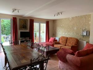 sala de estar con mesa de madera y sillas en Gite L'Eglantier, en Luçon