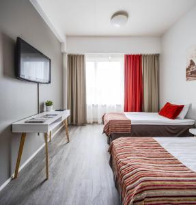um quarto de hotel com duas camas e uma secretária em Hotel Seurahuone Riihimäki em Riihimäki