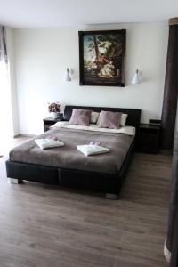 a bedroom with a large bed with two towels on it at Vila Romnesa in Ignalina