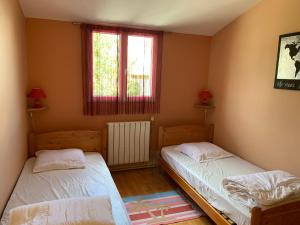 two beds in a room with two windows at Gite L'Eglantier in Luçon