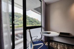 a room with a desk and a table and a window at The Tango Hotel Taipei Shilin in Taipei