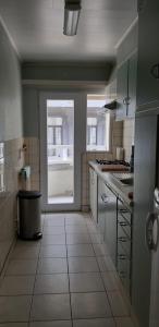 een keuken met een groot raam en een grote witte tegelvloer bij Apartment Hertstraat in Oostende