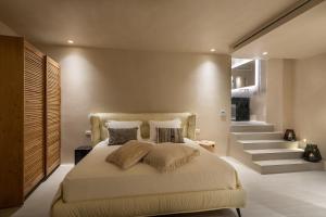 1 dormitorio con cama con almohadas y escalera en Island Mykonos Suites en Mykonos