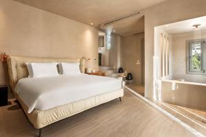 a bedroom with a large bed and a bathroom at Island Mykonos Suites in Mikonos