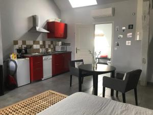 kuchnia z czerwonymi szafkami oraz stołem i krzesłami w obiekcie Gite NiLou w mieście Amboise