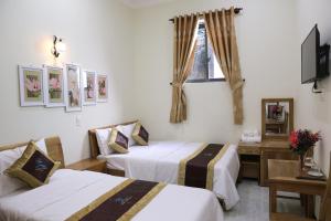 una camera d'albergo con due letti e una televisione di Thanh Trang Hotel a Con Dao