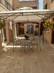 un patio con mesa y sillas bajo una sombrilla en Irene's Apartments en Limassol