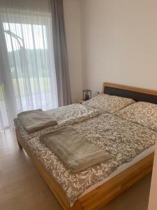 a large bed in a bedroom with a large window at Apartment am Weinberg in Ehrenhausen
