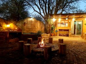 eine Feuerstelle vor einem Haus in der Nacht in der Unterkunft Kiburi Cottage @ Kruger in Marloth Park