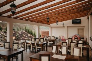 a restaurant with wooden ceilings and tables and chairs at ROYAL M in Sabinov