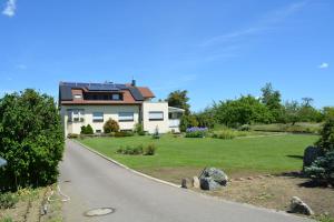 une maison avec un jardin et une route dans l'établissement Ferienwohnung Plocher, à Immenstaad am Bodensee