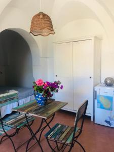 Una habitación con una mesa con un jarrón de flores. en Studio Alli en Pantelleria