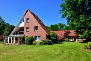 a large brick house with a large yard at Der Eichenhof in Hellwege