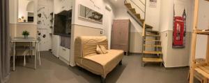 Habitación con escalera, silla y mesa. en Little Dream Residenza - Napoli, en Nápoles