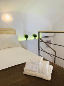 1 cama con toalla blanca en el suelo en Little Dream Residenza - Napoli, en Nápoles