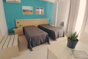 Zimmer mit 2 Betten in einem Zimmer mit blauen Wänden in der Unterkunft Bed & Breakfast Tiziana in Castellammare del Golfo