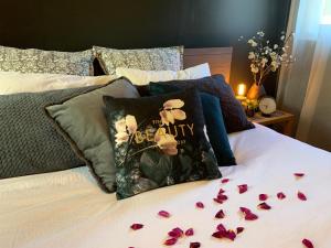 a bed with purple petals on it with flowers on it at Couple's Spa Retreat Resort Villa with complimentary champagne upon arrival in Cowes