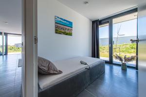 een slaapkamer met een bed en een groot raam bij De Groote Duynen in Kamperland