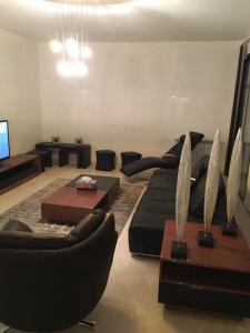 un soggiorno con divano nero e tavolo di Beit Misk a Beirut