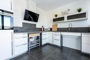 a kitchen with white cabinets and a sink at De Groote Duynen in Kamperland