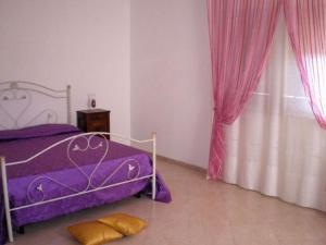 a bedroom with a purple bed and a window at B&B Pacheco in Paceco