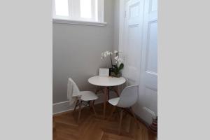 Una pequeña mesa y sillas en una habitación con puerta en Gawler Heritage Accommodation, en Gawler