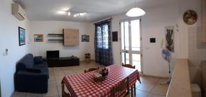トッレ・サン・ジョヴァンニ・ウジェントにあるAppartamenti in villetta a Torre San Giovanniのリビングルーム(テーブル、青いソファ付)