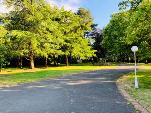 una carretera en un parque con árboles y una señal de stop en Villa du Bois Verts, en Les Herbiers
