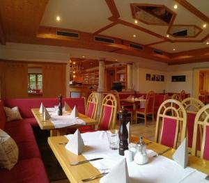 a restaurant with tables and chairs with napkins on them at Zur Guten Einkehr in Bayrischzell