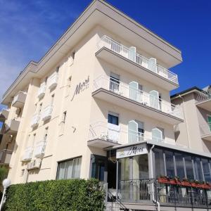 ein Apartmenthaus mit Balkonen und Büschen in der Unterkunft Hotel Morri in Bellaria-Igea Marina