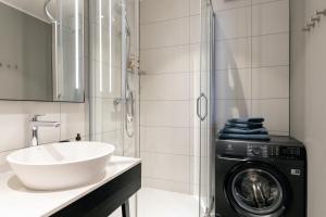 Un baño con lavadora y lavabo. en Brand New, Family-friendly with a great location - Moon Apartment, en Ventspils 43 fotos más