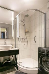 un baño con ducha y lavabo en Brand New, Family-friendly with a great location - Moon Apartment, en Ventspils