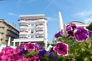 a group of flowers in front of a white building at Hotel Oxford in Lido di Jesolo
