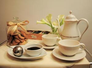 un tavolo con tazze e piattini e un bollitore per il tè di B&B A Casa di Tiziana - Roma a Roma