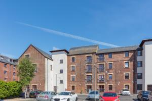 um grupo de edifícios com carros estacionados num parque de estacionamento em Granary Suite No22 - Donnini Apartments em Ayr