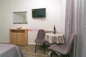 a bedroom with a table and two chairs and a television at Apartments & rooms Merita in Brela