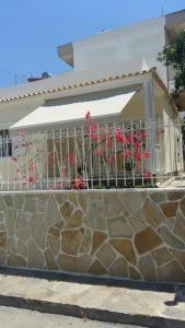 - un balcon orné de fleurs roses sur un mur en pierre dans l'établissement NN Deluxe room near Athens airport, à Spáta