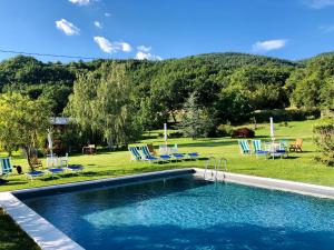 een zwembad in een tuin met stoelen en tafels bij Agriturismo Tripala in Minucciano