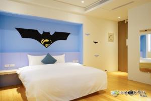 馬公市的住宿－宸楓民宿，卧室配有一张挂着 ⁇ 蝠标志的床铺