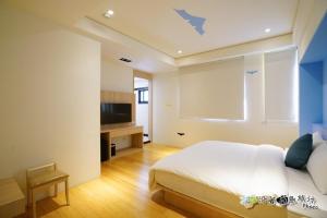 馬公市的住宿－宸楓民宿，一间卧室配有一张大床和电视